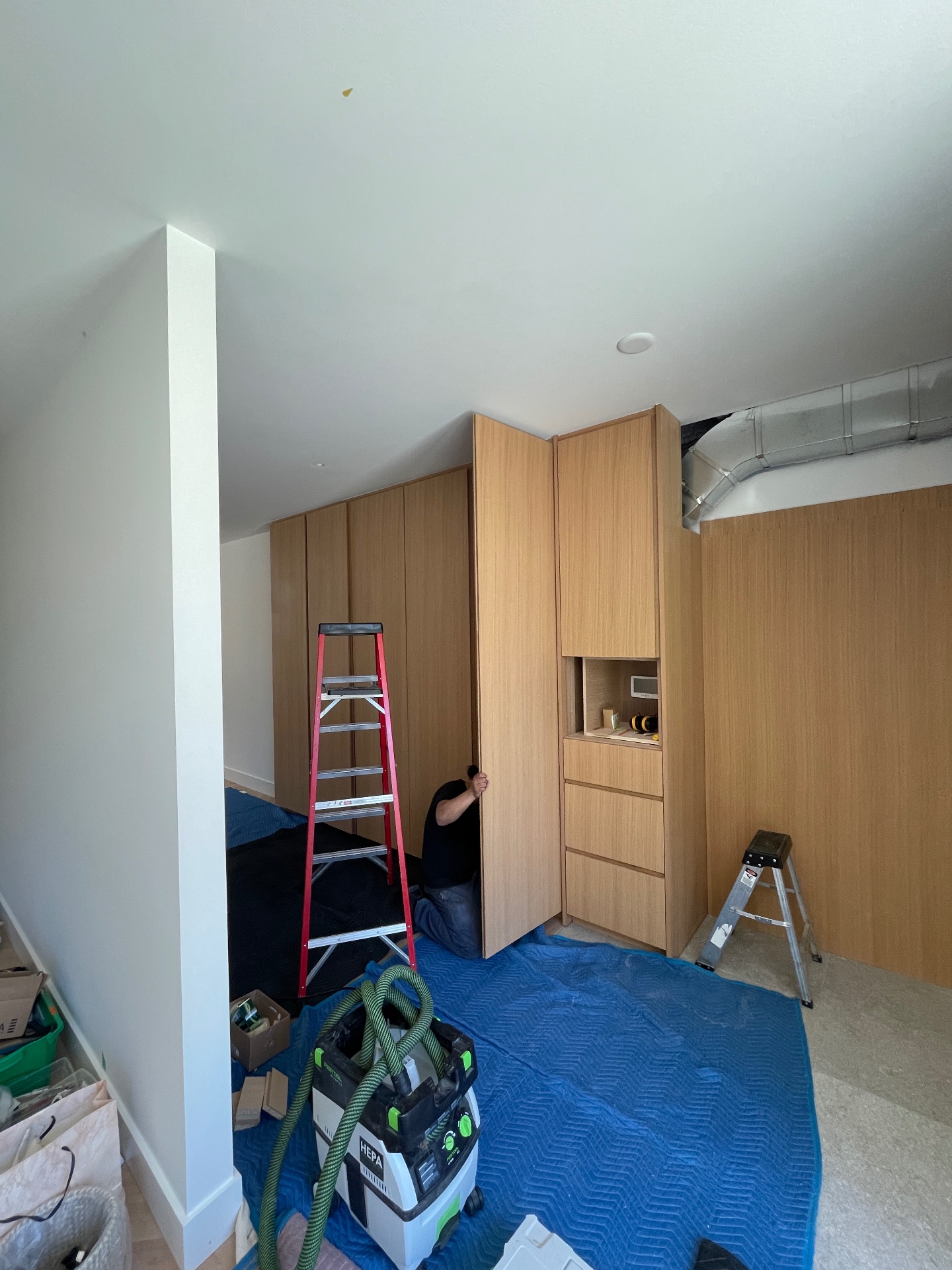 Craftsman adjusting the oak wardrobe doors during on-site installation