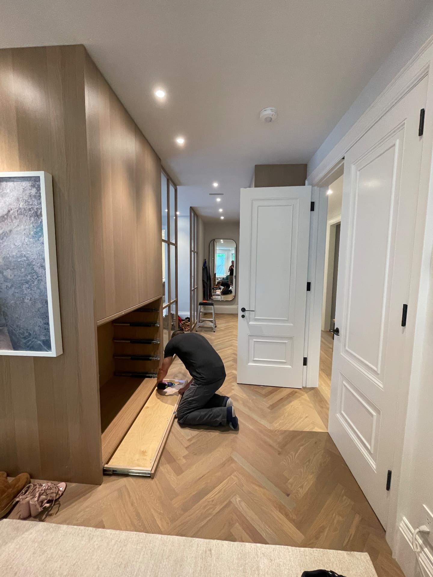 Craftsman fitting a drawer front into the oak dressing-room storage on site
