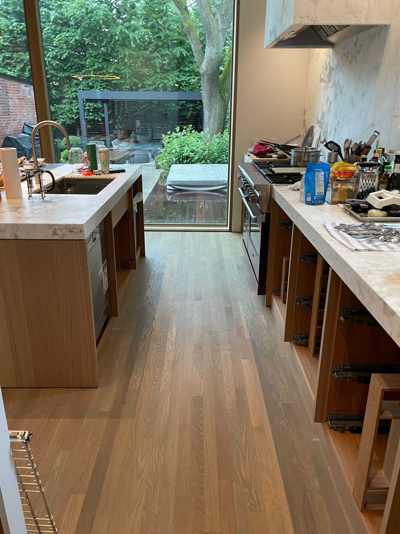 Galley between island and range wall in white oak and marble