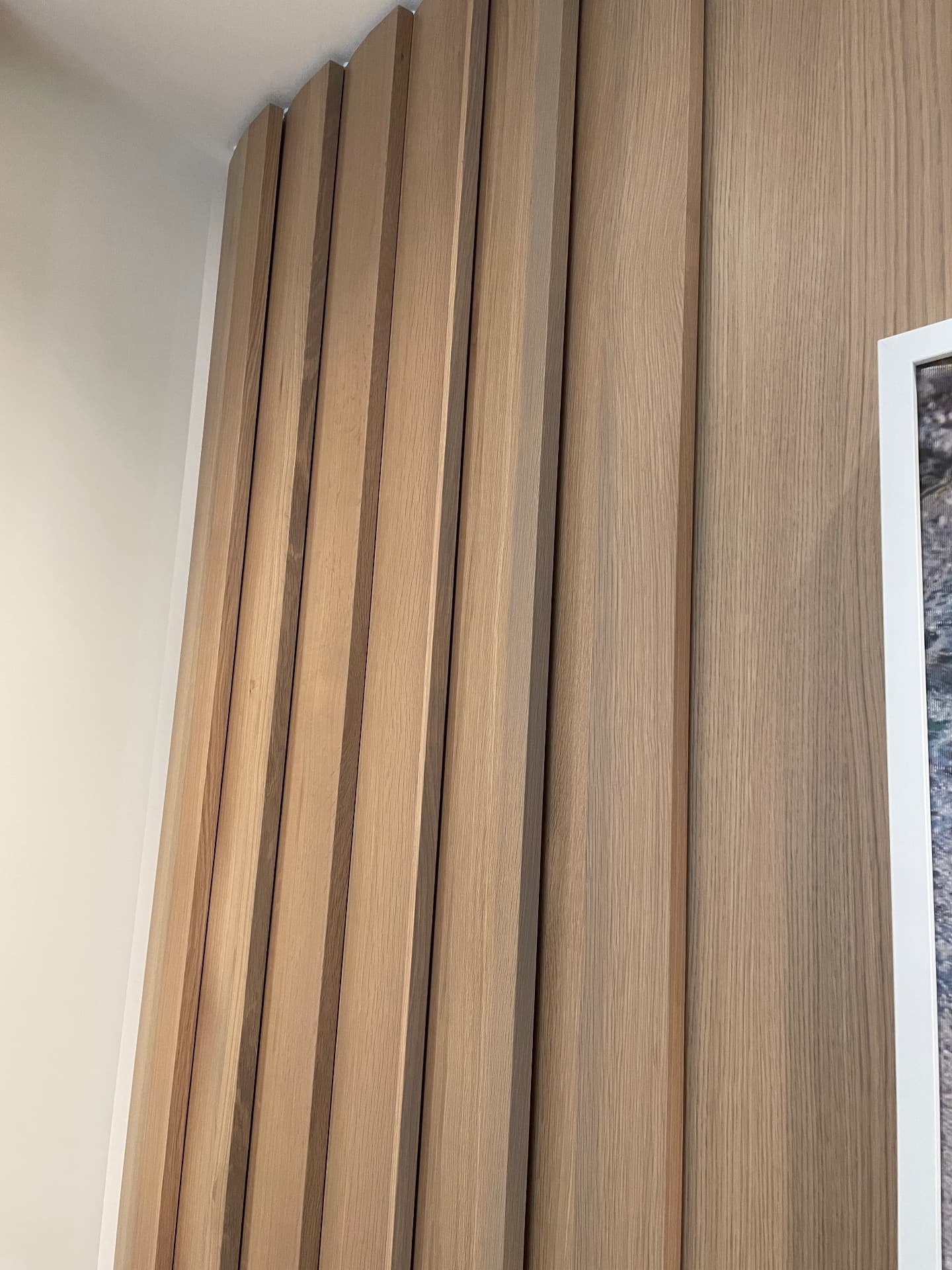 Close-up of the solid oak slatted panelling turning a corner