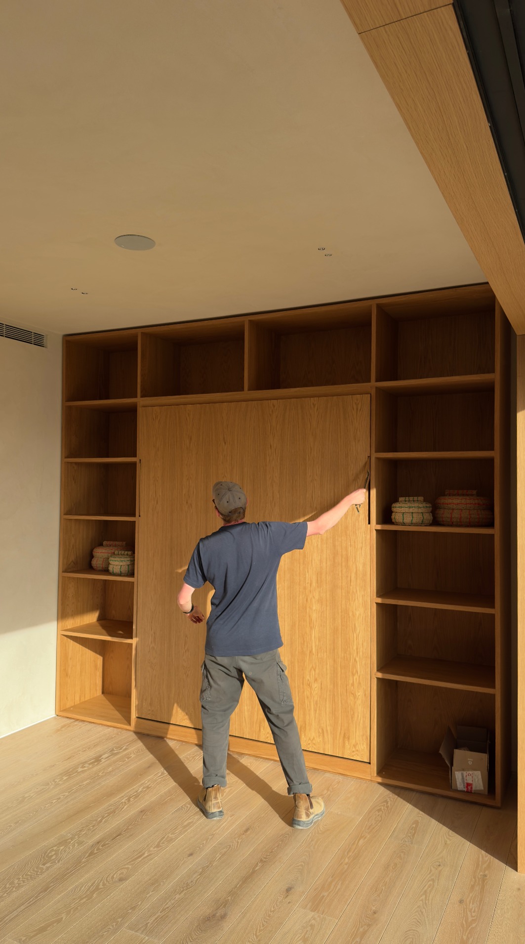Closing the murphy bed back into the oak wall unit