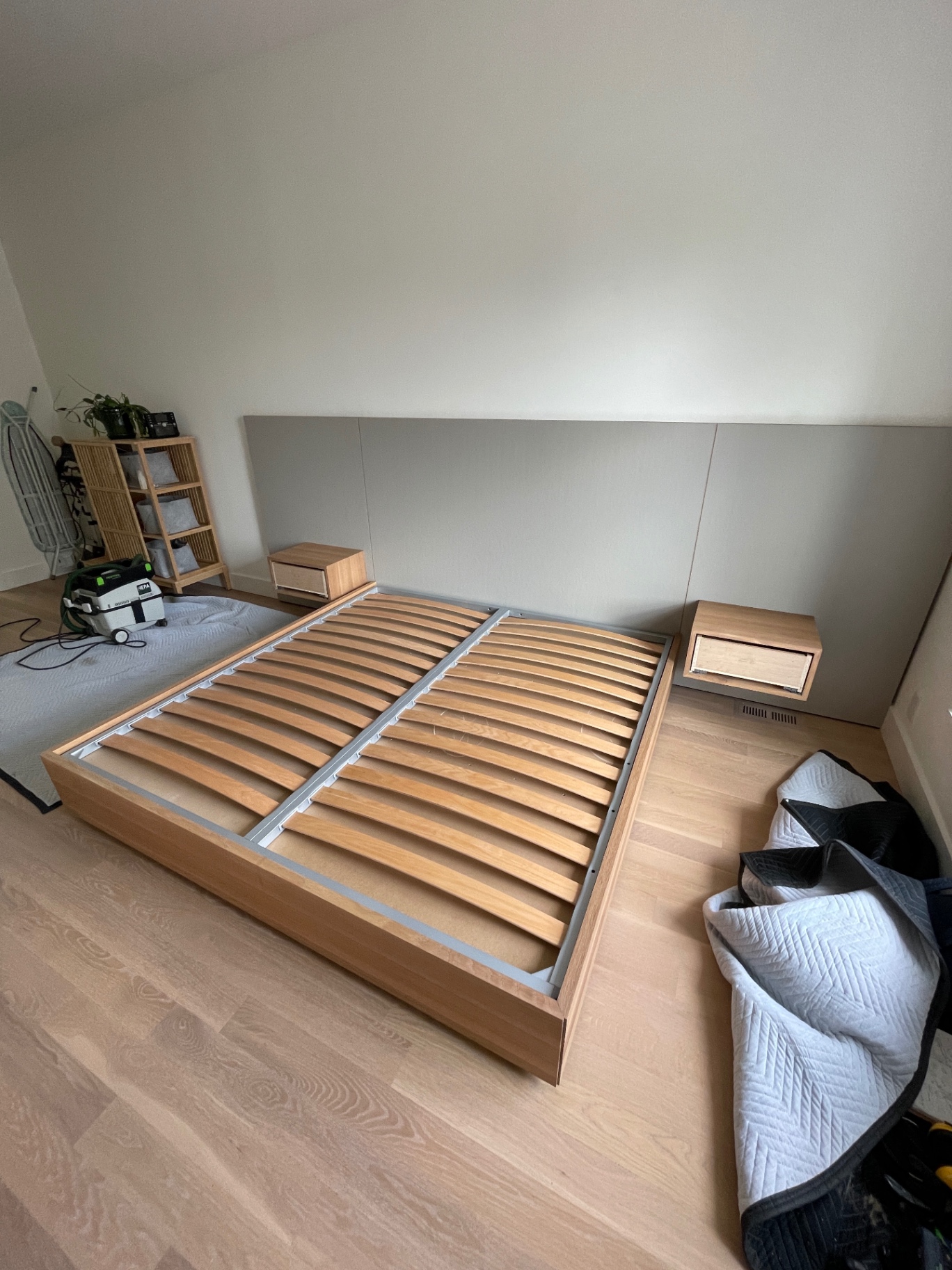 Oak bed frame with sprung slats exposed, floating nightstands and headboard panel