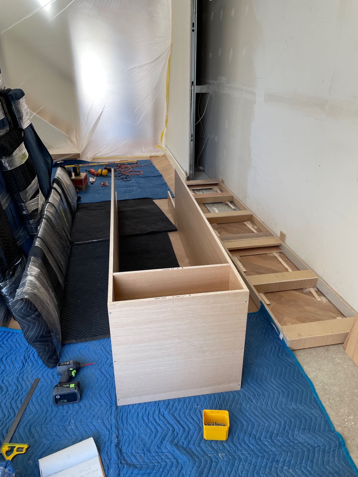 Oak plinth and the start of the cabinet assembly on a protective blanket in the workshop