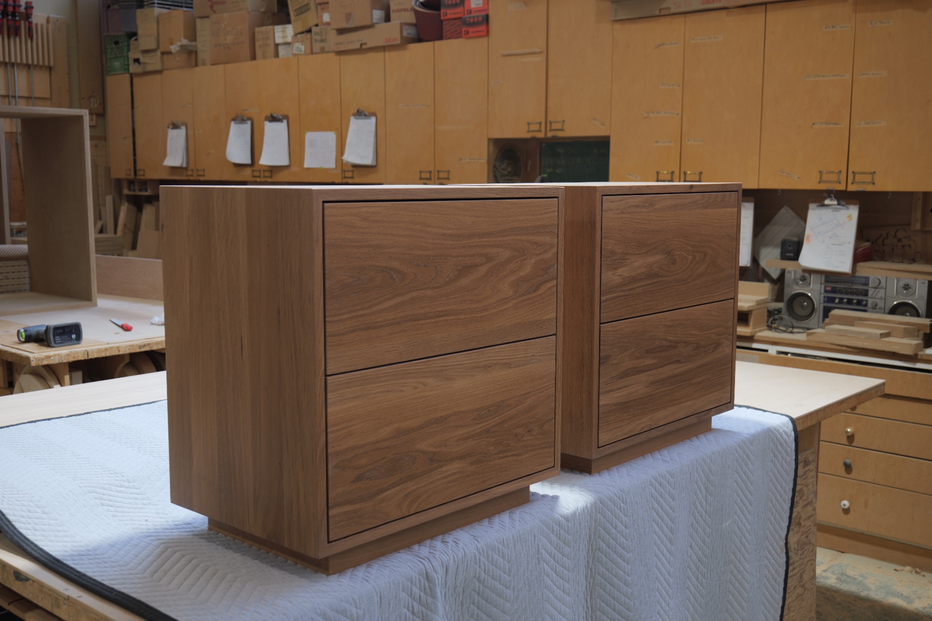 Pair of oak nightstands at a three-quarter angle in the workshop