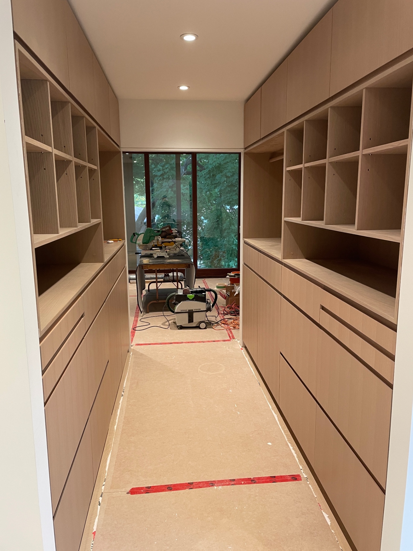 Closet build mid-progress with miter saw set up at the window