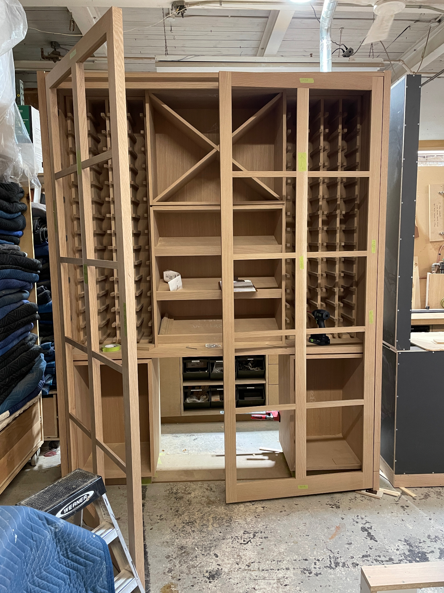 Full white oak wine cellar dry-fitted in the workshop with bottle racks and diamond bins