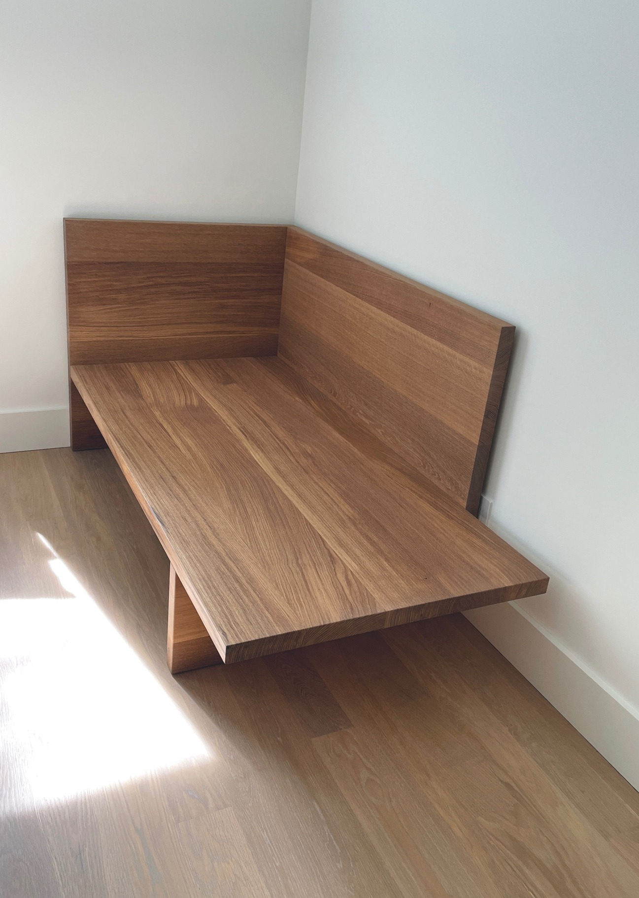 Bare solid oak chaise built into a bedroom corner