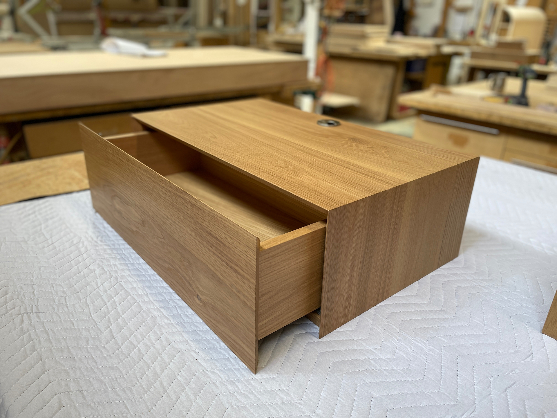 Close view of the open drawer and mitred oak case on the floating nightstand
