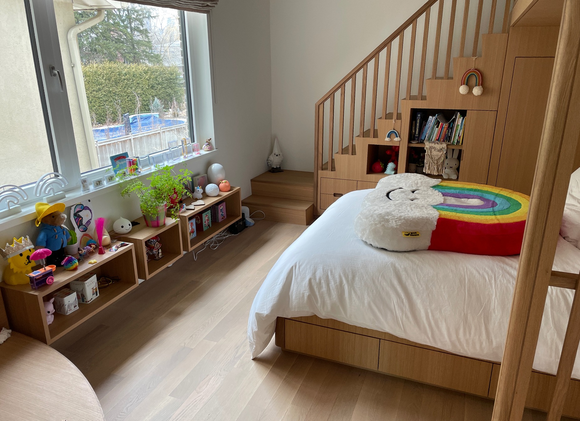 Quarto de criança em carvalho com cama em mezanino, escada com arrumação e estantes decoradas