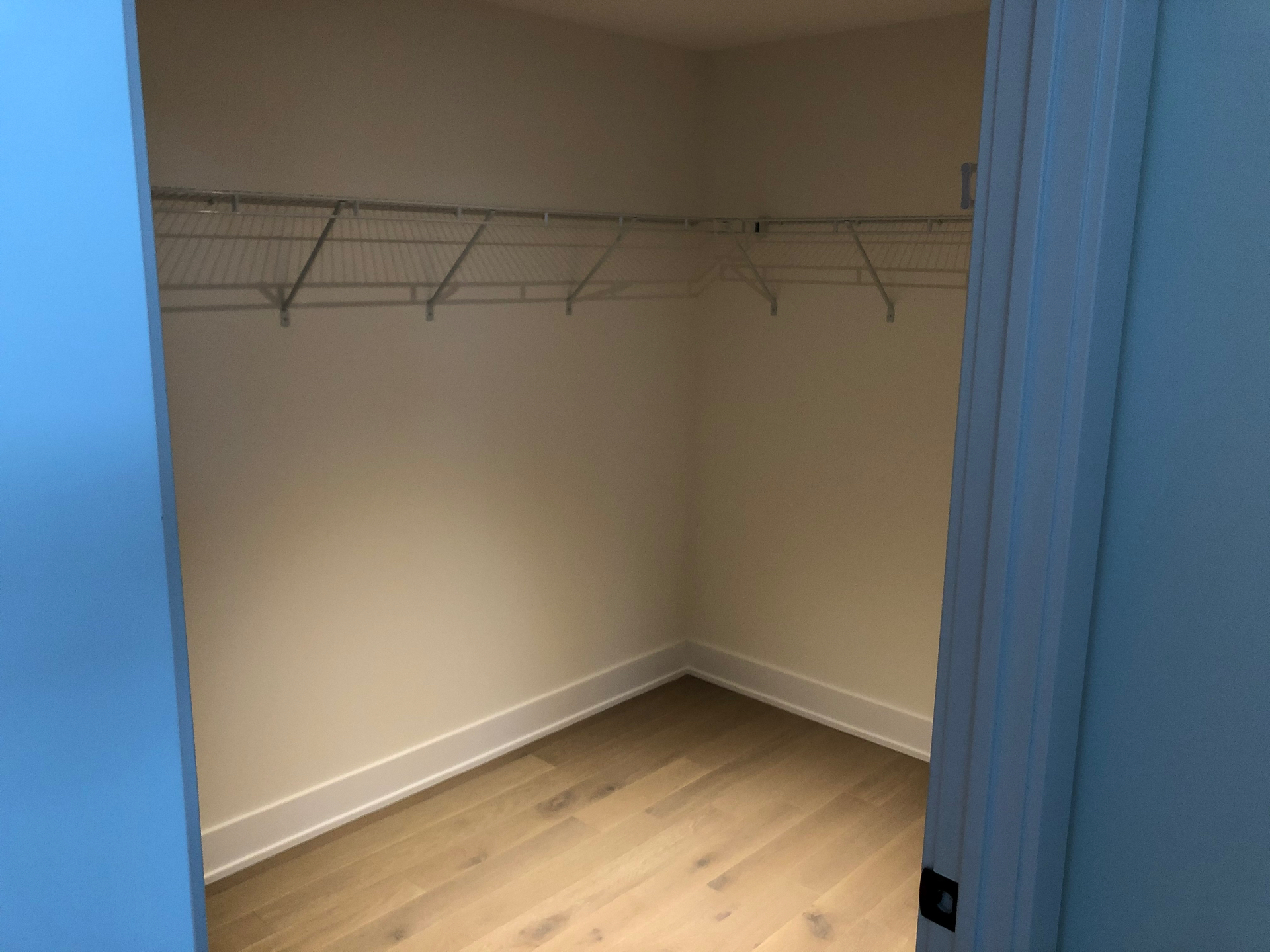 Antes: closet de apartamento vazio com uma prateleira de arame e varão