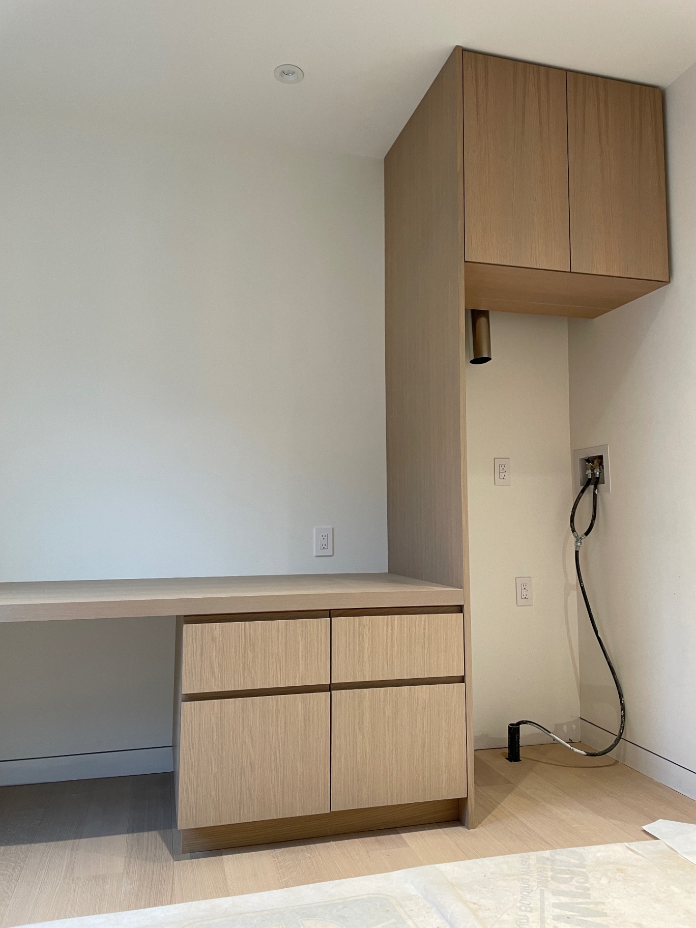 Vanity from the side with upper cabinet and brass sconce