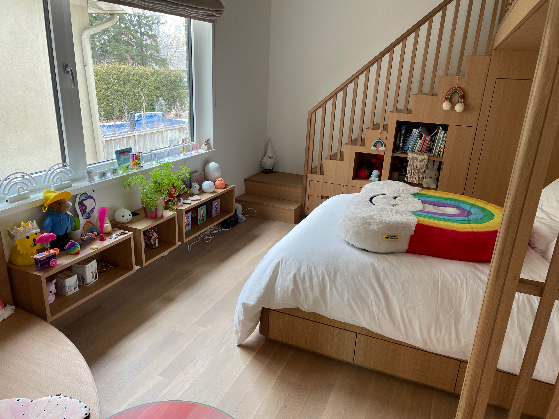 Quarto de criança em carvalho com cama em mezanino, escada com arrumação e estantes decoradas