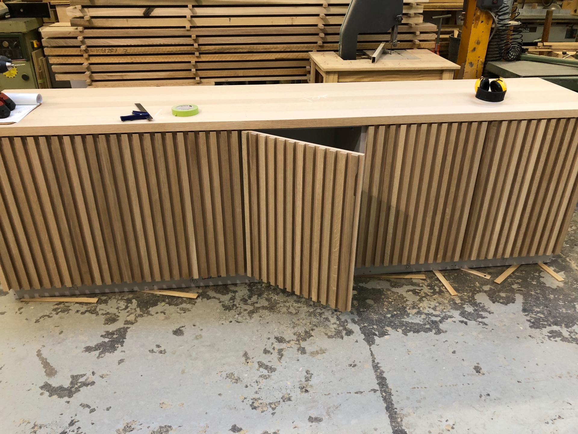 One of the fluted oak doors opened in the workshop showing the carcass behind