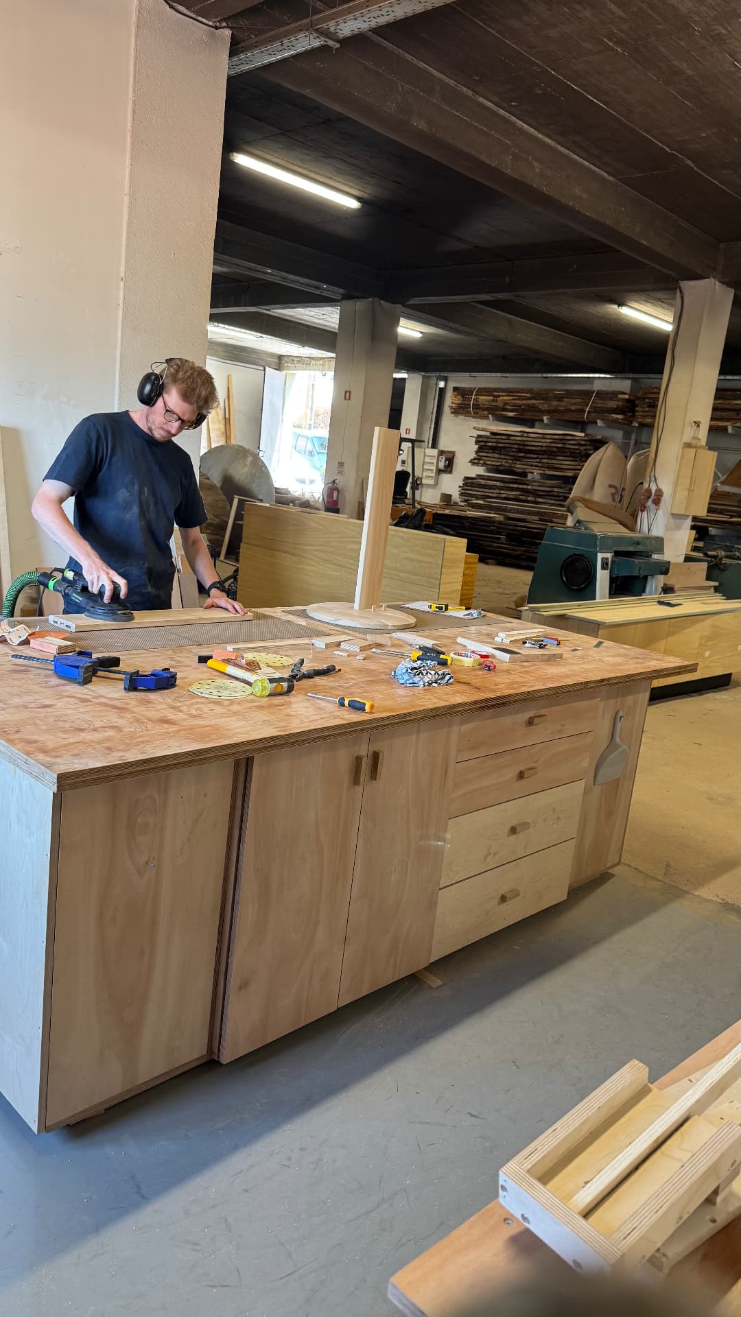 Hand-sanding a panel with a dust-extracted sander