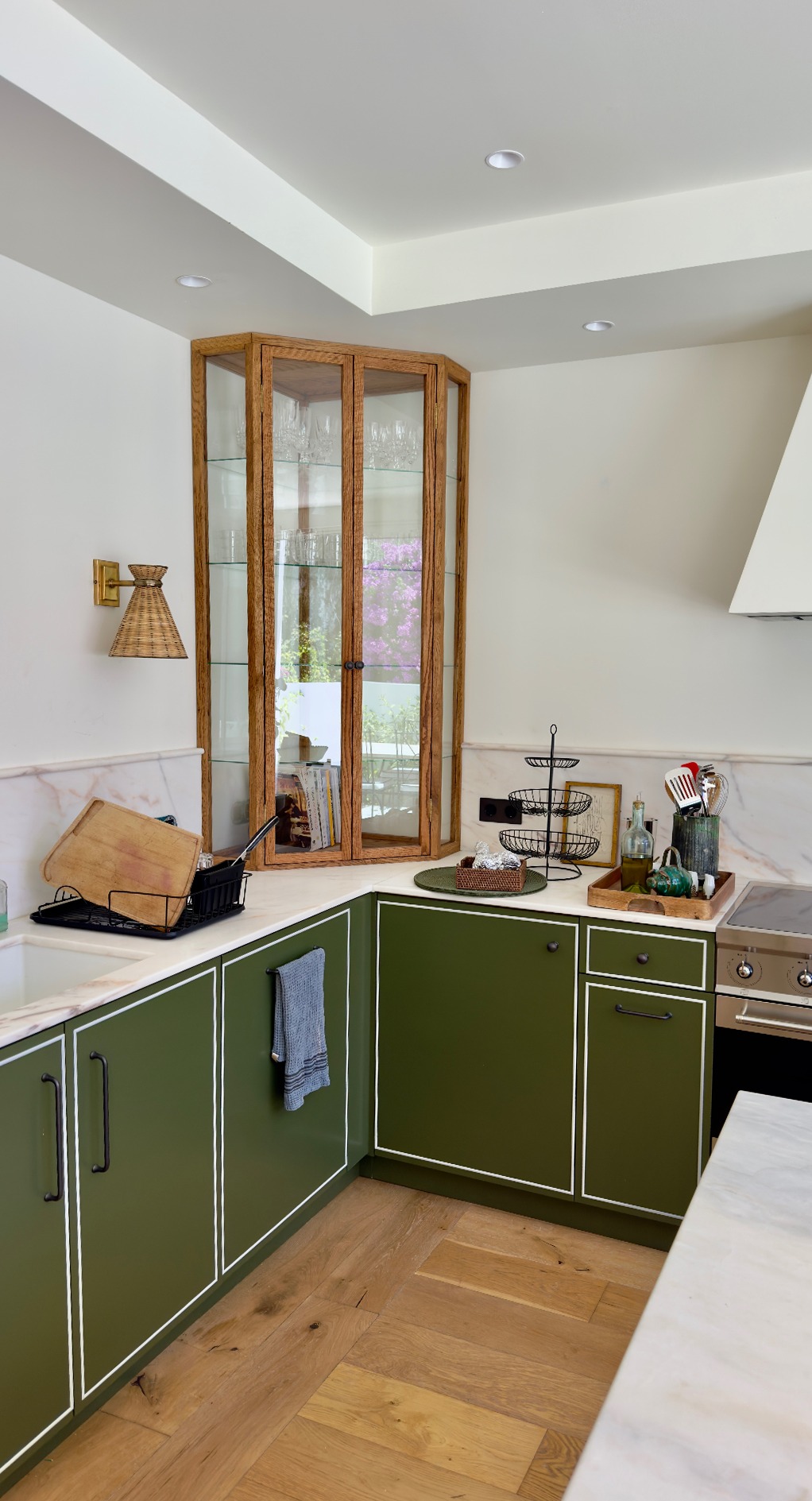 Green base cabinets with marble splashback and glazed oak corner cabinet