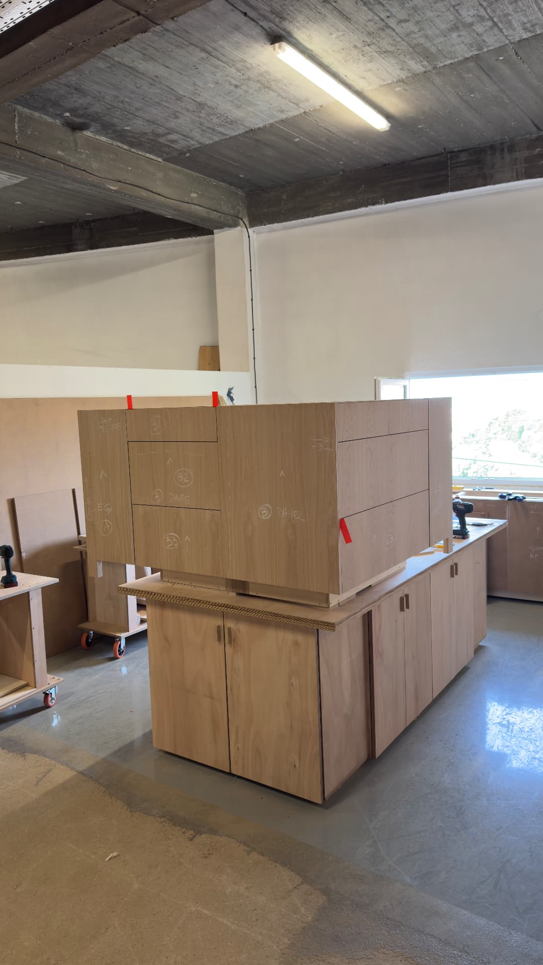 Oak kitchen cabinets stacked and labelled in the shop