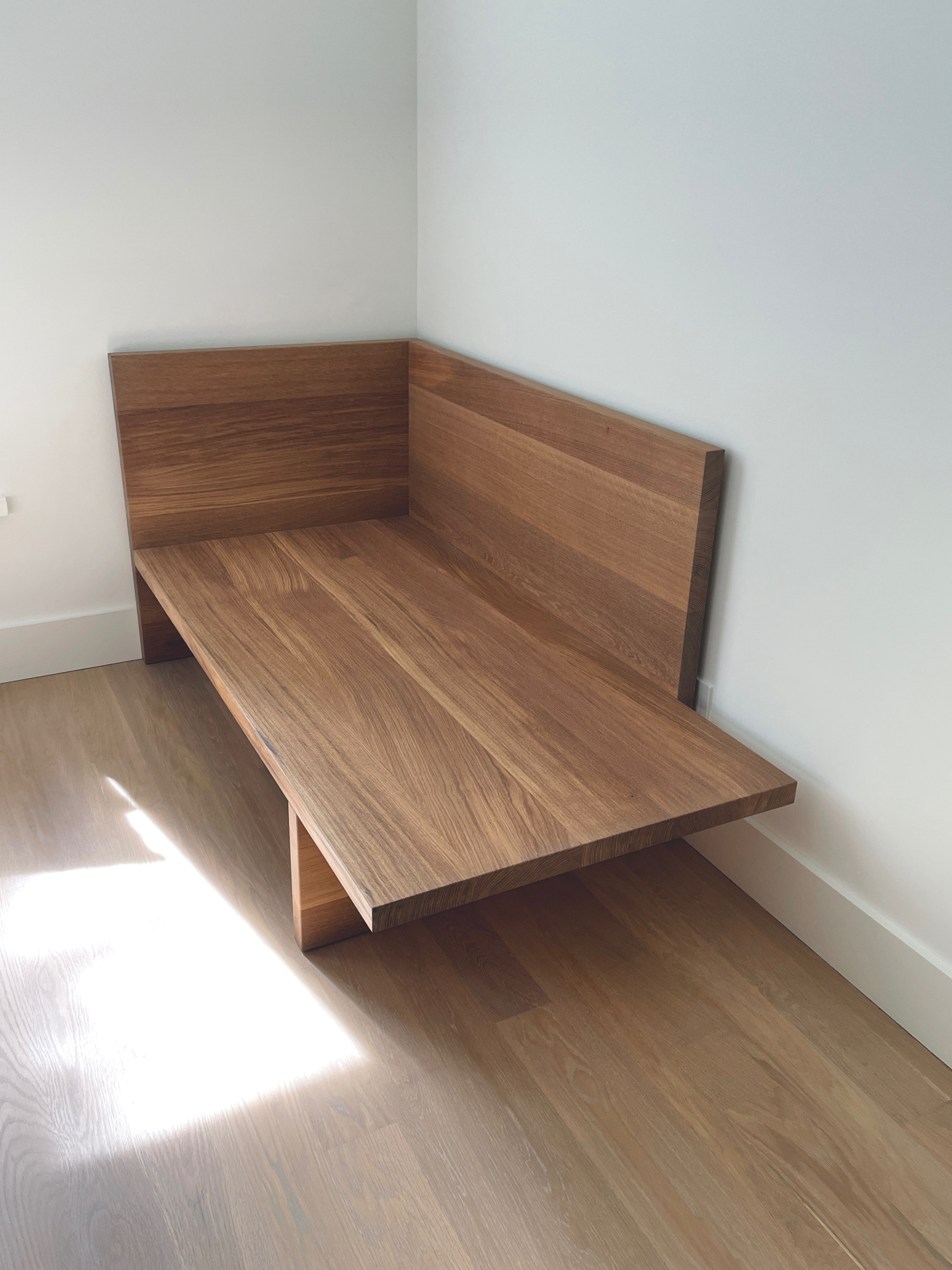 Bare solid oak chaise built into a bedroom corner