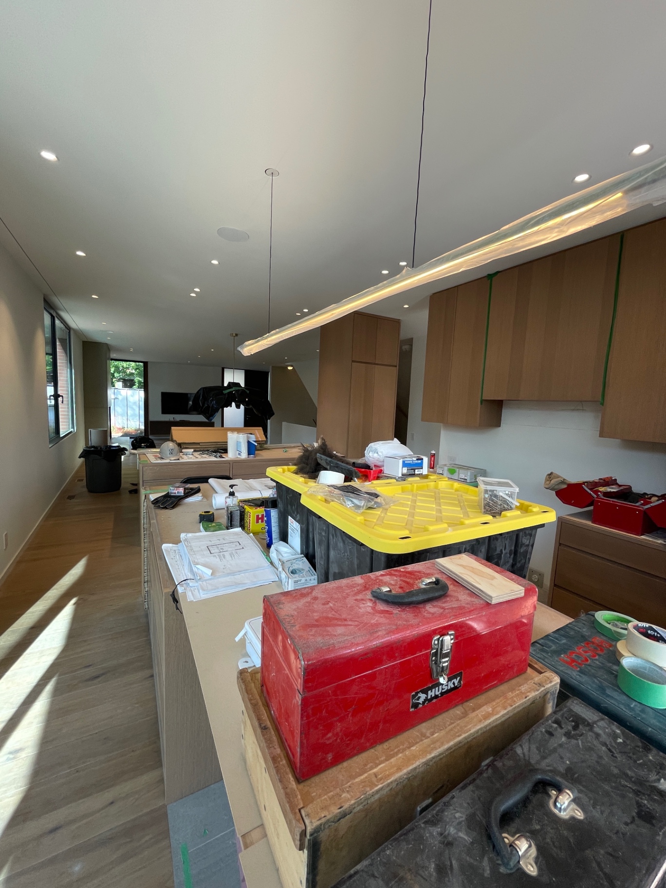 Cozinha longa em carvalho ao longo da casa com suspensão LED linear