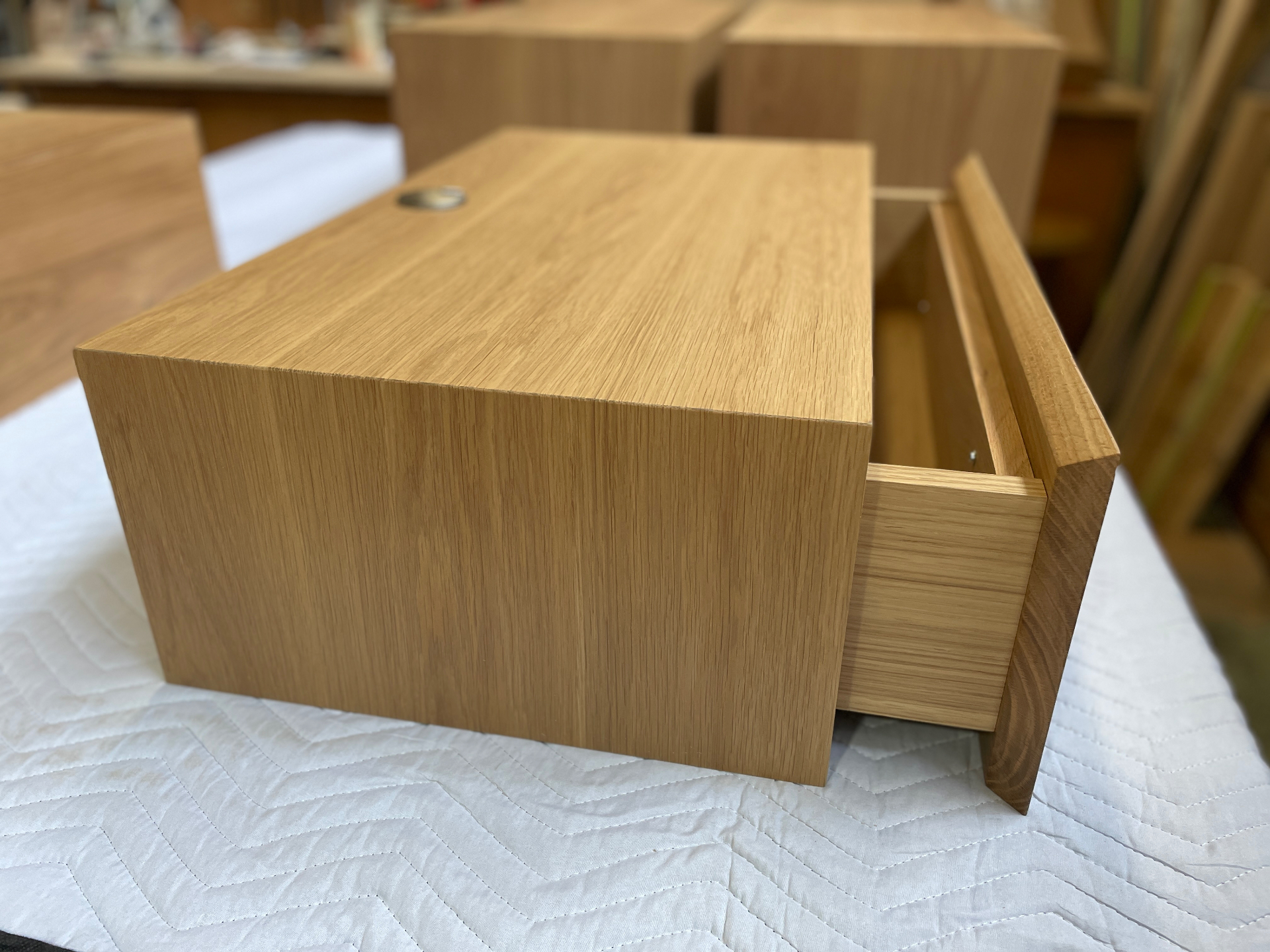 Side view of the floating nightstand showing the open drawer and oak grain